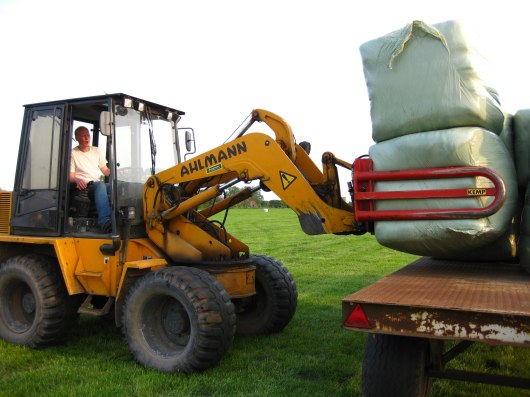 Balen met shovel op platte wagen